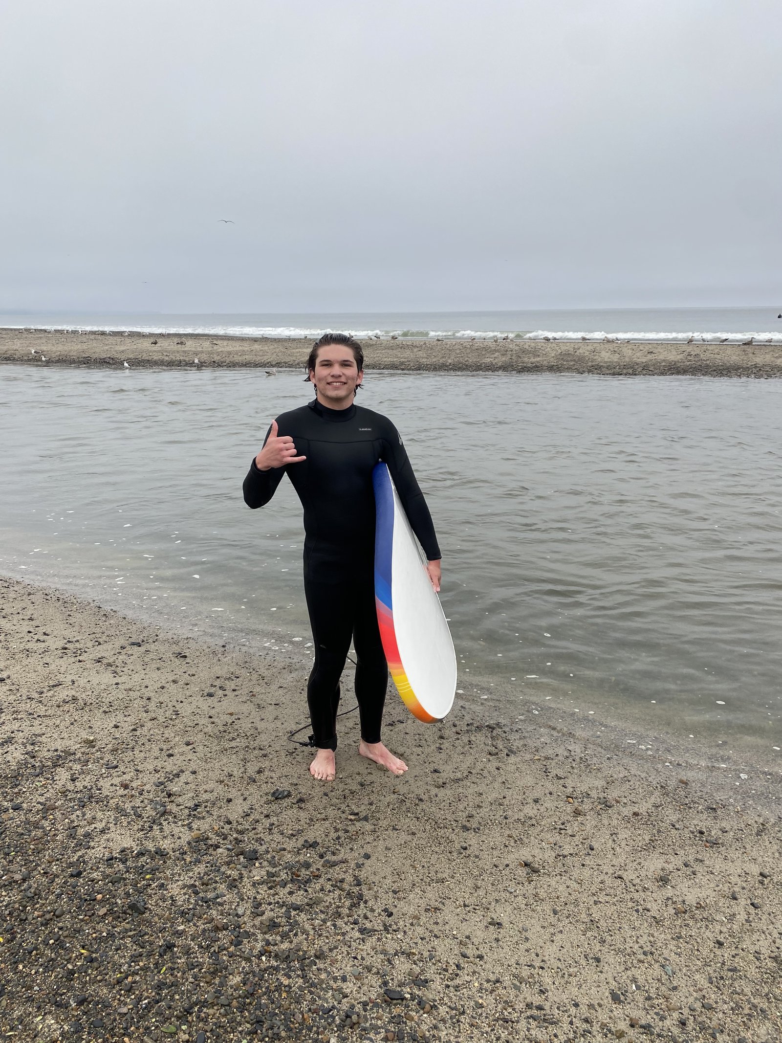Cooper Carlsen holding a surfboard on the beach